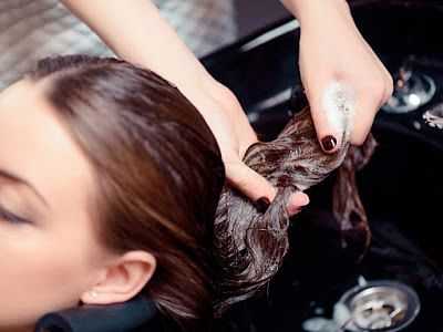 Person receiving a professional hair wash at a salon sink.